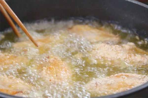 Chiên cánh gà trong chảo ngập dầu. 